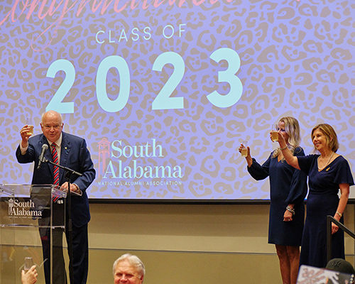 President Bonner, Vice President Kent, and Margaret Sullivan holding up champagne glasses to toast the class of 2023.