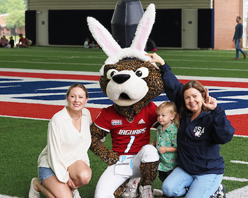 Dr. Paige Vituilli with family and Southpaw in bunny ears at easter egg hunt.