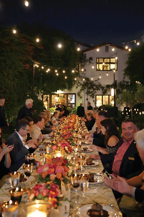 Dinner table outside with alumni at fundraiser event.