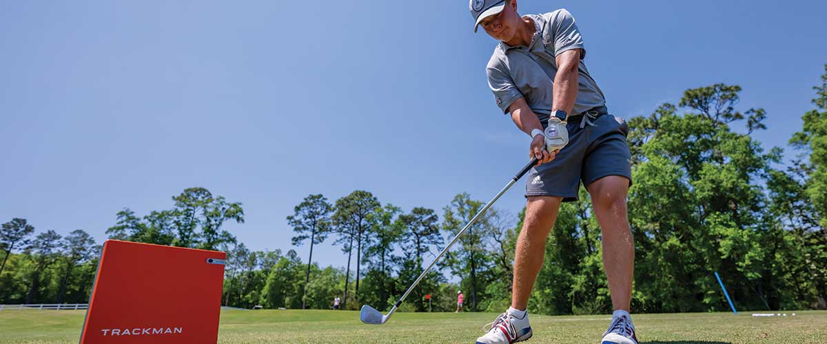 Student playing golf with Trackman device.