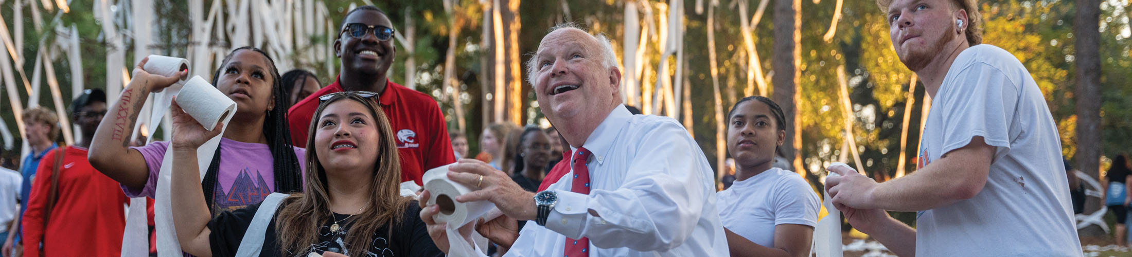 President Bonner throwing toilet paper with students at Junk the Jungle.