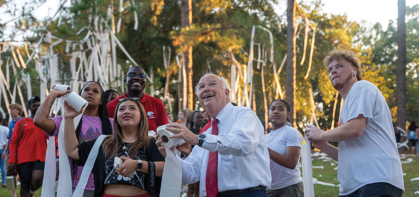 President Bonner throwing toilet paper with students at Junk the Jungle.