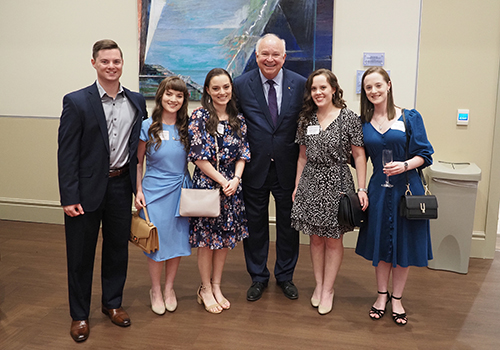 Five recent alumni standing with President Bonner.