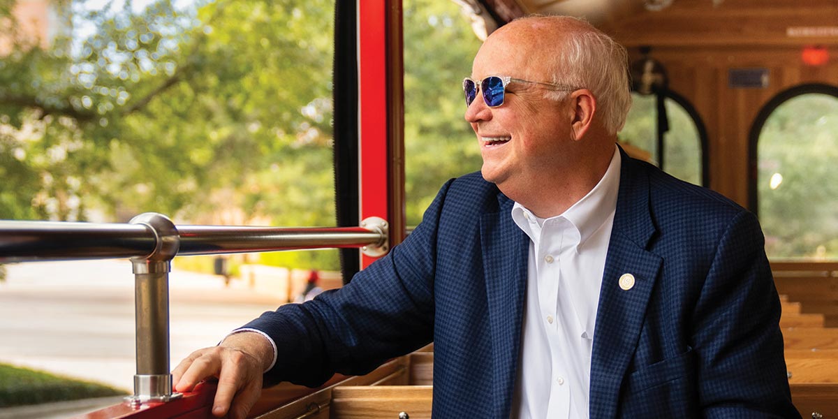 President Bonner riding the University Trolley.