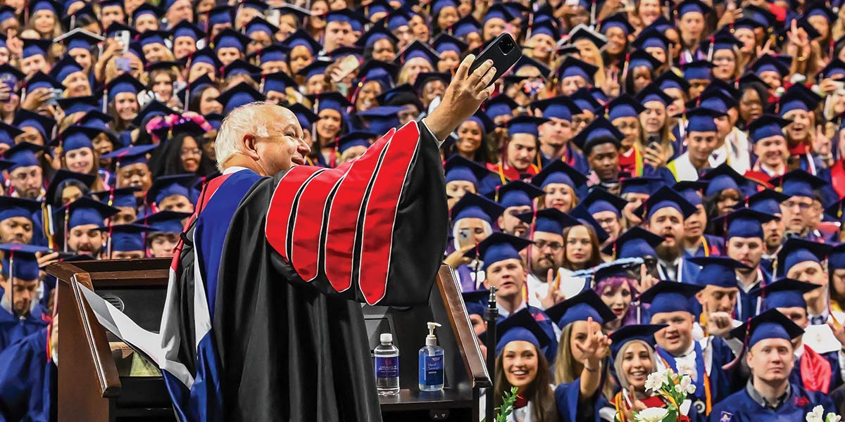 President Bonner taking a photo of the graduates at graduation.