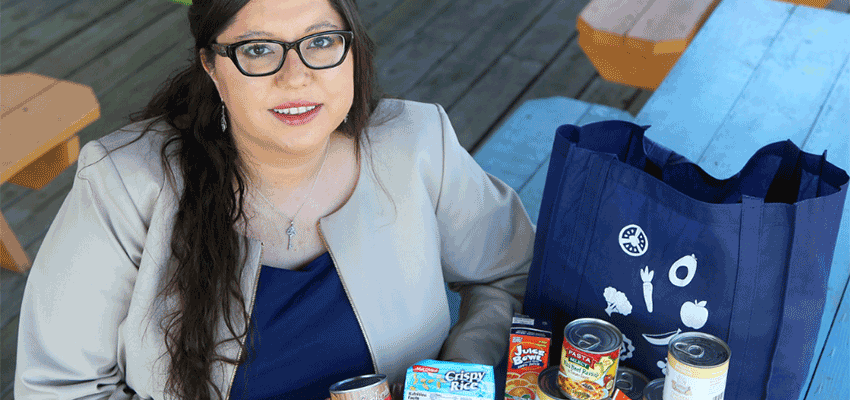 Eugenie Sellier holding food to donate. data-lightbox='featured'