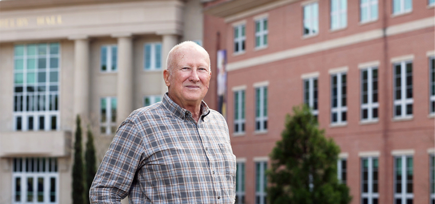 William B. Burnsed Jr. standing in front of Shelby Hall data-lightbox='featured'