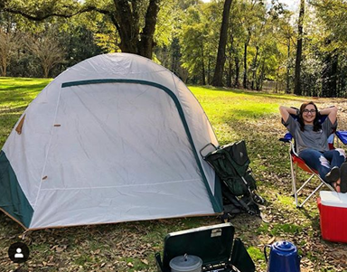 Female sitting in chair outside of tent