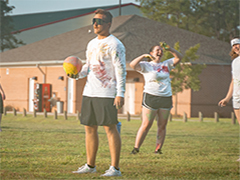 Students playing dodgeball outside on campus.
