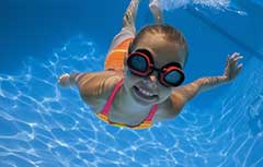 Young girl in goggles swimming