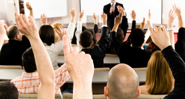 Group raising their hand in a classroom setting,