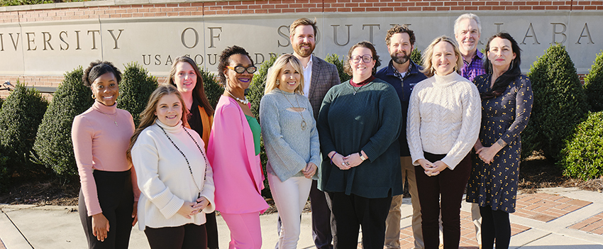 Group picture of Counseling and Testing staff outside in front of USA Sign.