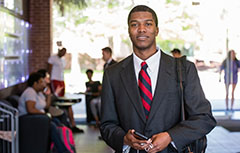 Male student in suit inside of MCOB Building lobby,