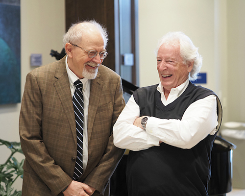 Two alumni members laughing during Richard Hayes event.