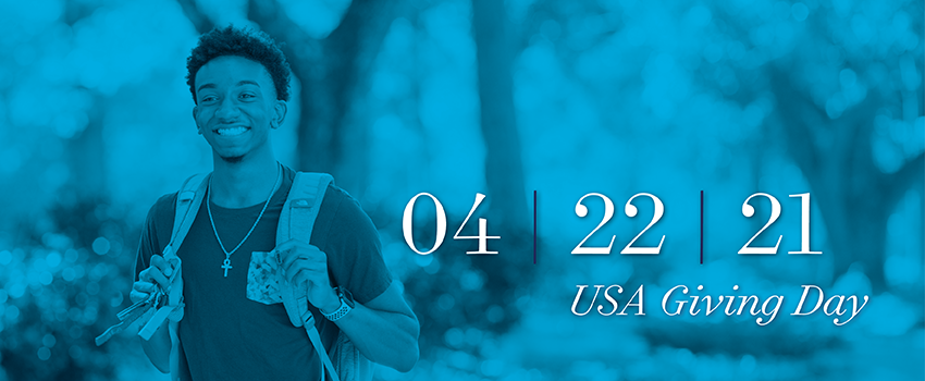 Male student smiling with backpack on with the text USA Giving Day 4/22/21