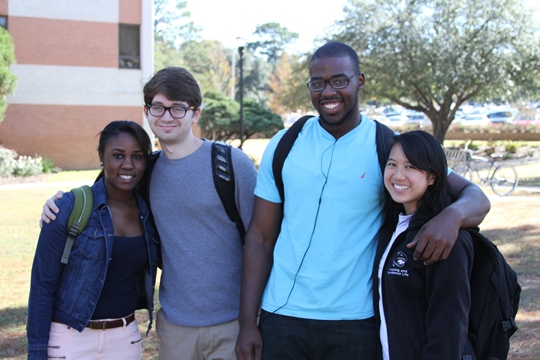 Two guys and two girls with arms around each other