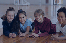 Kids laying on their stomach on the floor.