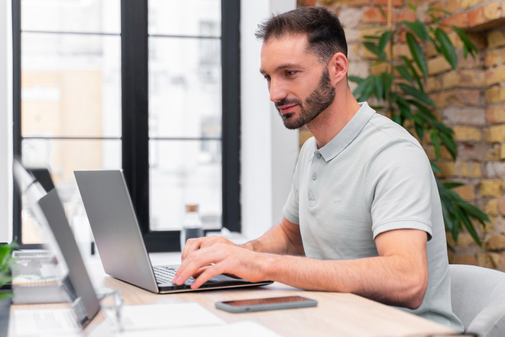 A man typing on a laptop