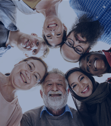People working together with arms around each other from the back.