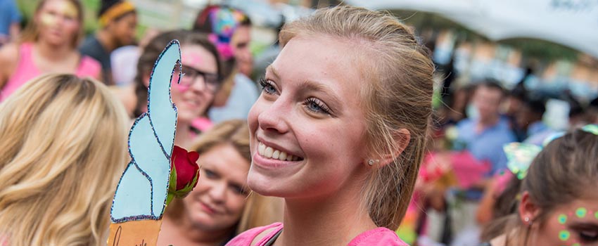 Sorority member smiling in a crowd at bid day.