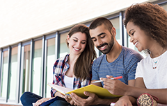 Three students looking at book