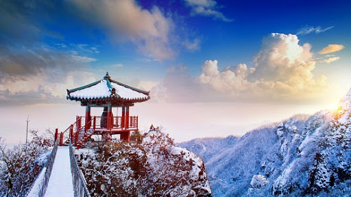 Mountains covered in snow in Asia with bridge.