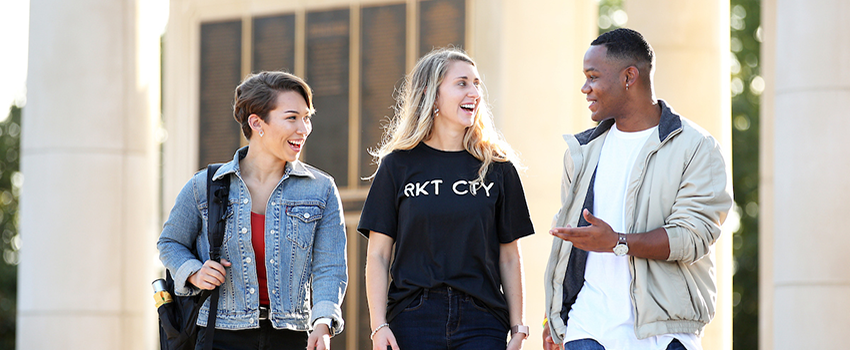 Three students walking and talking outside at South's campus.