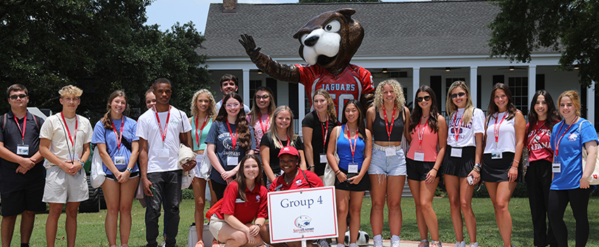 Students standing in front of Southpaw statue.