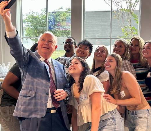 President Bonner taking a selfie with students.