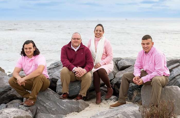 Family sits on rocks on a beach
