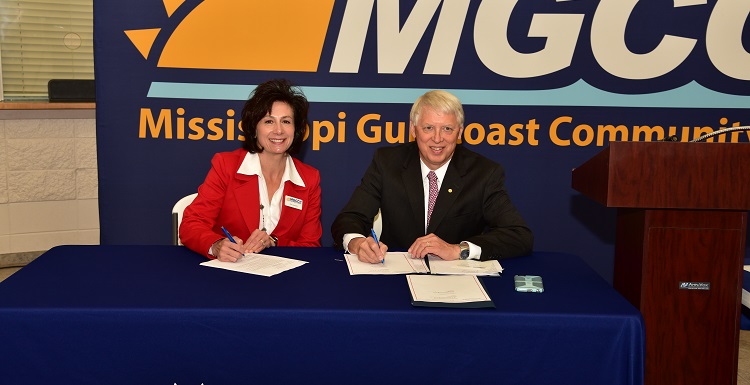 Dr. Mary Graham, Mississippi Gulf Coast Community College president, left, and Dr. Tony Waldrop, USA president, sign a commitment for the Pathway USA program.