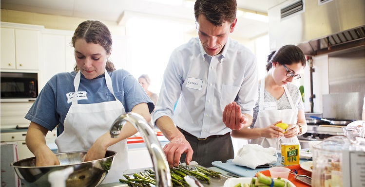 First-year medical student C.C. Linder of Spanish Fort, left, prepares raw vegetables for Shrimp Fra Diavolo with help from instructor Brenden Ingraham and nursing student Adriana Comerford during a pilot Culinary Medicine class at St. Paul’s Episcopal Church earlier this month.
