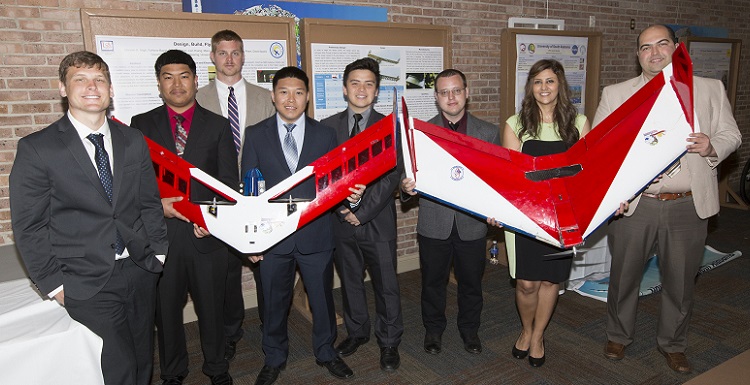 Marcus Houtzager, Lien Hoang, Caleb Cochran, Minh Lu, Michael Pham, David Sauers, Marzieh Atigh and Fariborz Bayat show off the aircraft they built for the Design/Build/Fly competition.