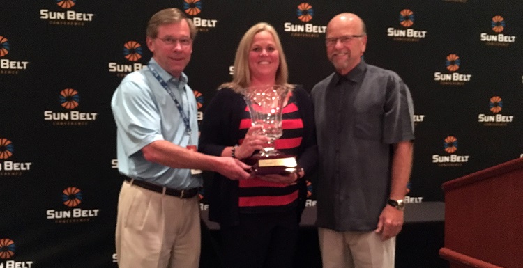 Dr. John Smith, left, USA executive vice president; Jinni Frisbey, USA associate athletic director of sports medicine and senior woman administrator; and Sun Belt Commissioner Karl Benson are pictured with the Bubas Cup, which was awarded to South Alabama for the second year in a row. 