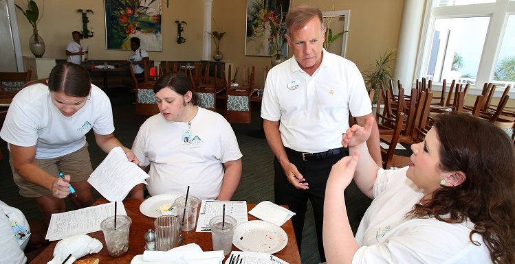 Carissa Barrios, right, a sophomore majoring in hospitality and tourism management, talks with David Clark, general manager of the Beach Club Resort; Dylan Ordeneaux, sophomore sociology major; and Christal Mashburn, executive housekeeper; about customer satisfaction scores and work schedules.