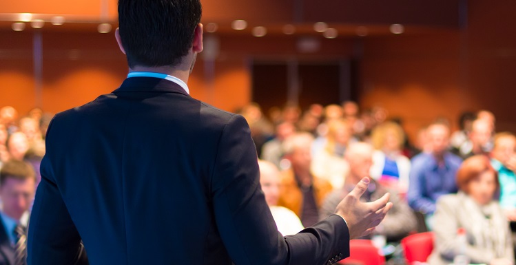 male speaker before classroom of students