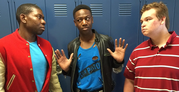 High school jocks Kurt (Desmond Bozeman) and Ram (Trenton Davis) harass the new kid, J.D. (Jeremiah Sims), in Theatre USA's production of Heathers the Musical.