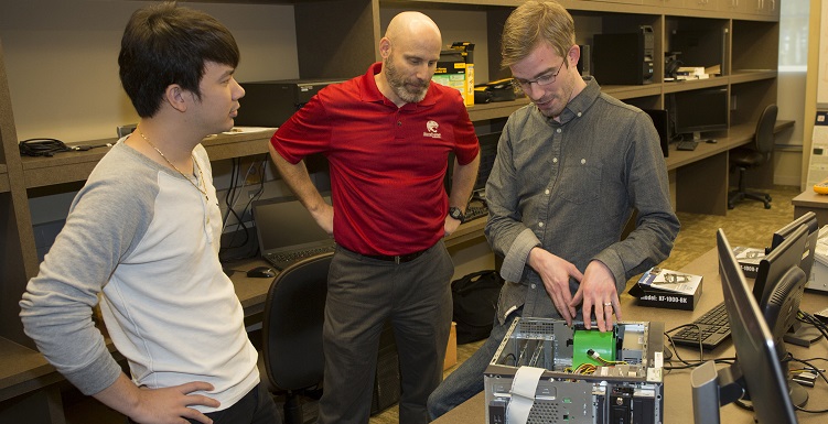 South students Thanh Nguyen, left, and Joel Dawson, right, meet with Dr. Todd Andel, associate professor of computing and principal investigator for a $4.1 million grant awarded to the School of Computing.