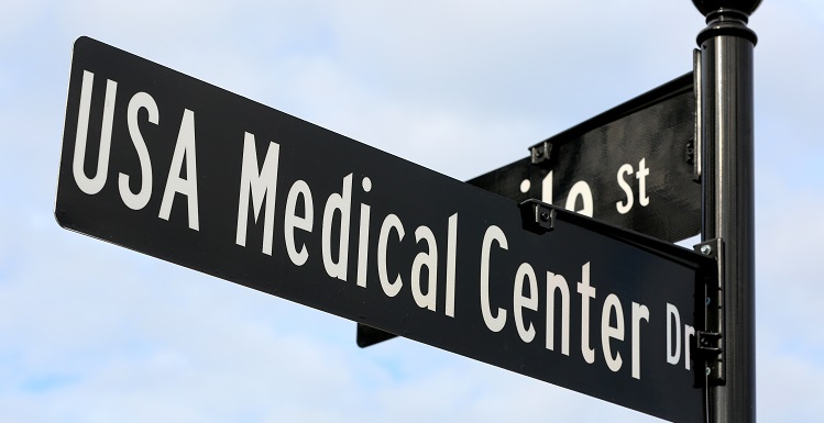 Elmer Sellers, retired USA Medical Center assistant administrator , unveils the new USA Medical Center sign at Mobile Street. The hospital houses the region's only Level I trauma center and has one of the busiest burn units in the country. 