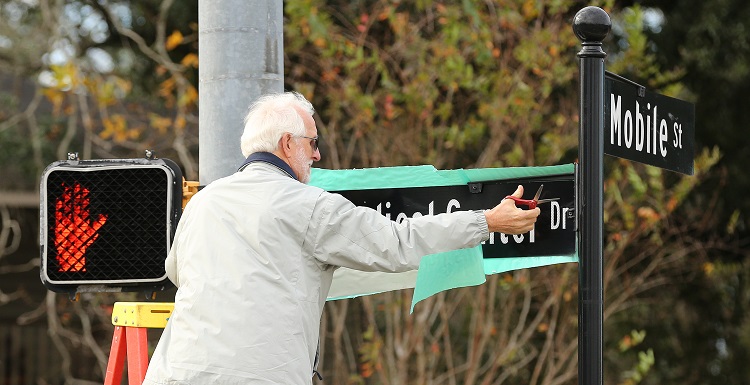 Elmer Sellers, retired USA Medical Center assistant administrator, unveils the new USA Medical Center sign at Mobile Street. The hospital houses the region's only Level I trauma center and has one of the busiest burn units in the country. data-lightbox='featured'