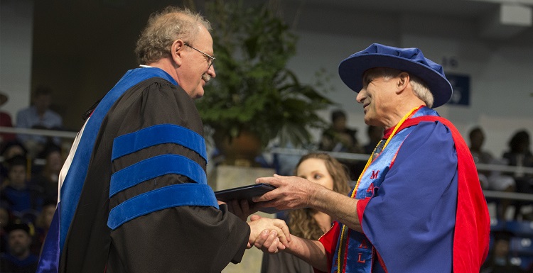 Dr. Doug Haywick, associate professor of geology, shakes the hand of Dr. Andrzej Wierzbicki, dean of the College of Arts and Sciences, at Commencement on May 6. Haywick earned a second bachelor's degree after taking classes beginning in 2002.