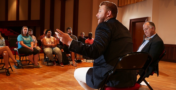 Nicholas Brownlee, front, met with music students during a visit to South, where he was taught as a student by Dr. Thomas Rowell, right, director of the USA Opera House.