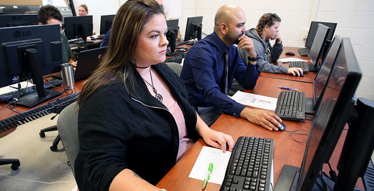 USA senior German Cruz-Torres, center, a native of Puerto Rico, concentrates on mapping areas of the island during the GeoClub’s Map-a-thon.