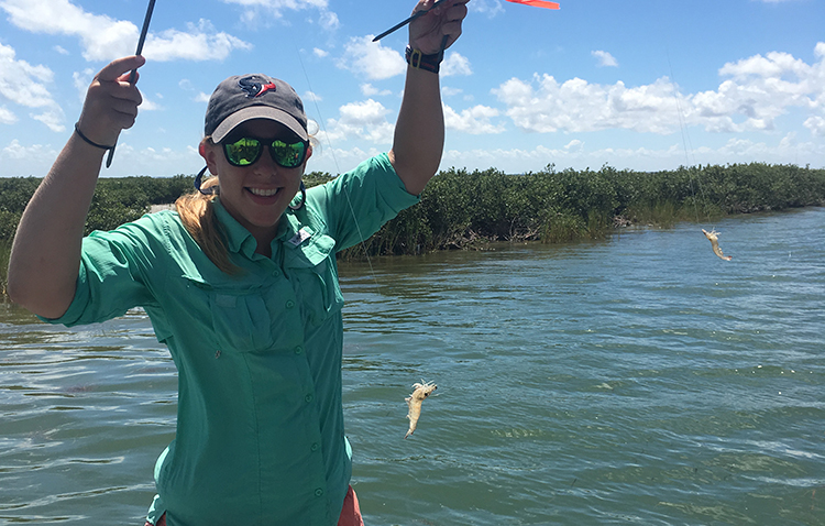 Ph.D student holds up a fishing line with a shrimp data-lightbox='featured'