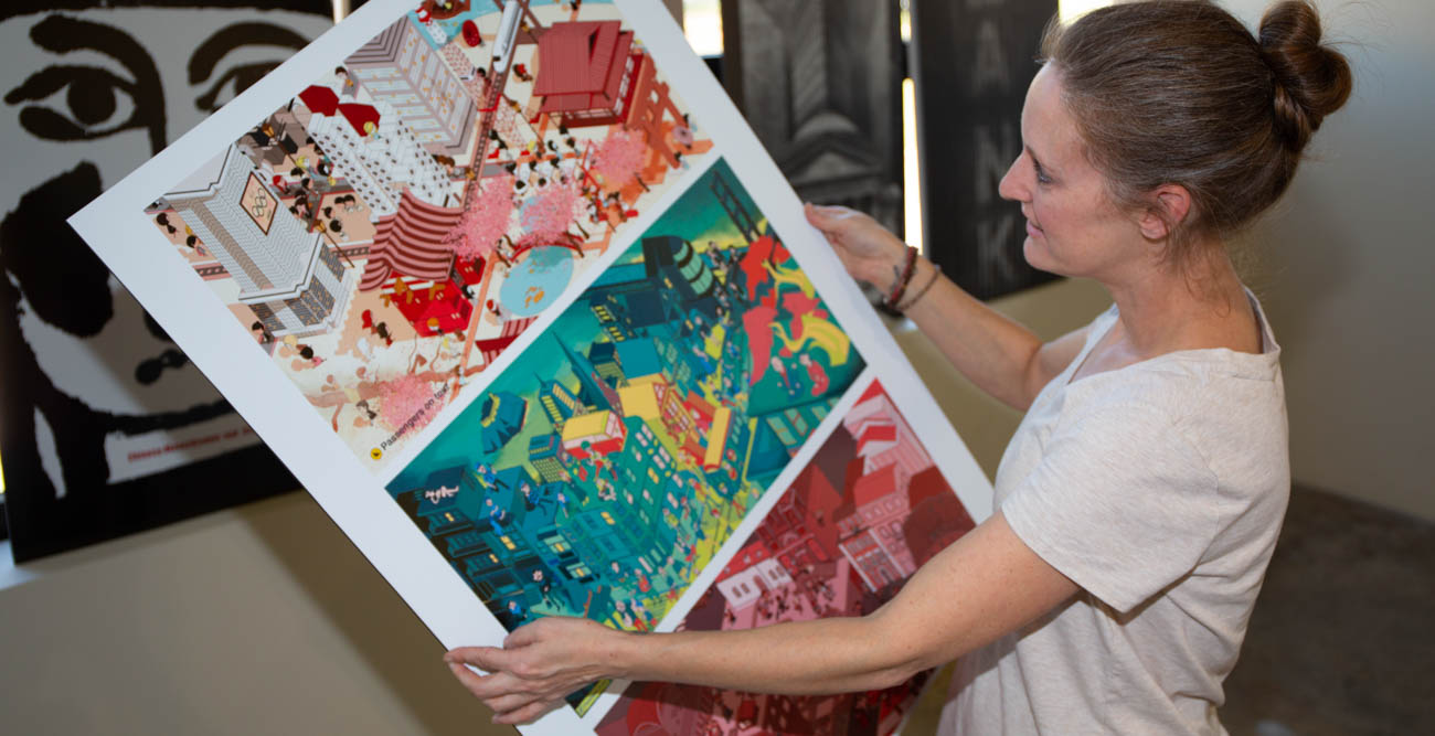 Graduate student Yvonne LeBrun prepares to hang the art for the Cross Connections 2018 International Exhibit of Design & Illustration.The exhibit runs through Oct. 31.