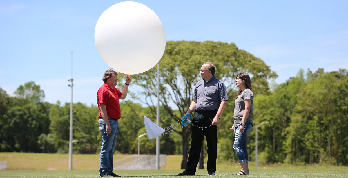 Dillon Blount, left, a senior meteorology major from Pelham, Ga.; Dr. Wesley Terwey, assistant professor of meteorology; and Amber Kulick, a junior meteorology major from Falkville, Ala., participate in the VORTEX weather balloon program that seeks to learn more about tornadoes in order to provide timelier forecasts. 