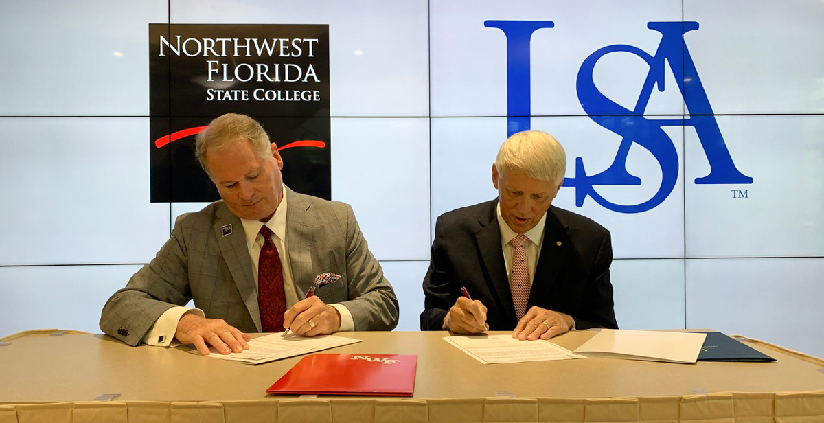  Dr. Devin Stephenson, left, Northwest Florida State College president, and Dr. Tony Waldrop, University of South Alabama president, sign an agreement that adds NWF State College to the list of Gulf Coast institutions that have joined South's Pathway USA program, increasing access to a four-year education for community college students. 