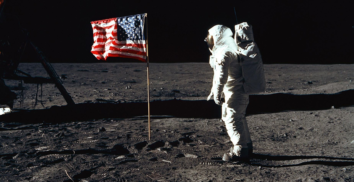 Astronaut Edwin "Buzz" E. Aldrin Jr., lunar module pilot of the first lunar landing mission, poses for a photograph beside the deployed United States flag. NASA photo.  