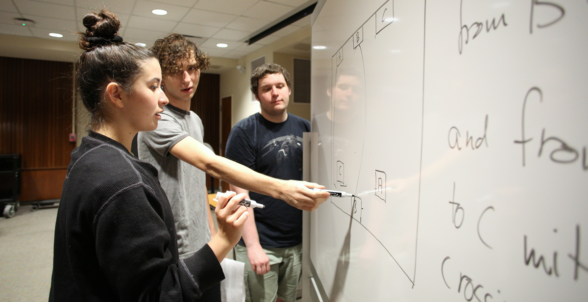 USA students John Pomerat, center, a sophomore computer science and mathematics major, along with Daniel Hodgins, a freshman engineering major, show Murphy High School student Mollee Bearden how to problem solve during a recent Math Circle session.