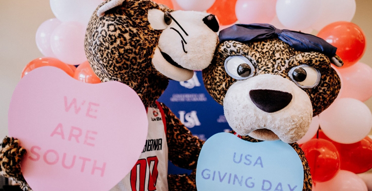 Southpaw and Pawla holding Giving Day Hearts